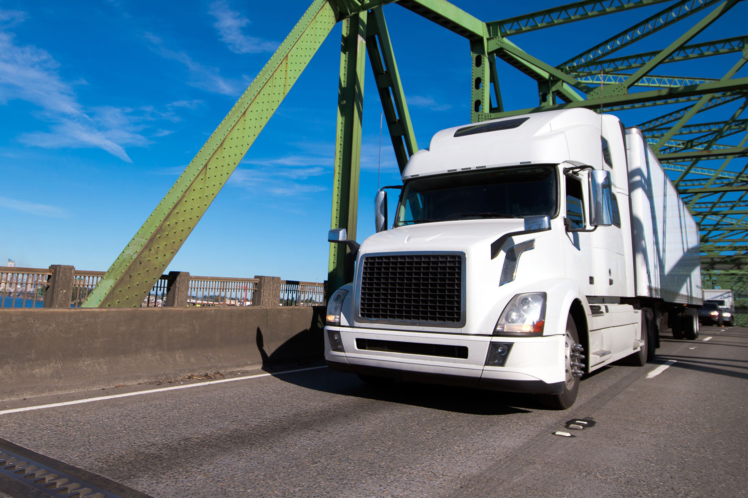 Sleep tractor trailer crossing grreen metal bridge