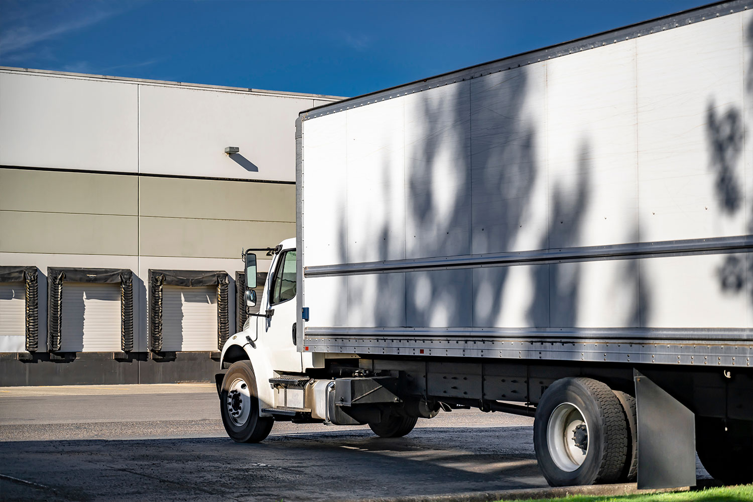 Logistics-Consulting-04 White box truck waiting at loading docks.