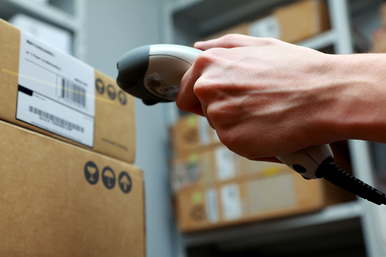 Logistics-Consulting-06 Close up of hand holding scanner in shipping department.