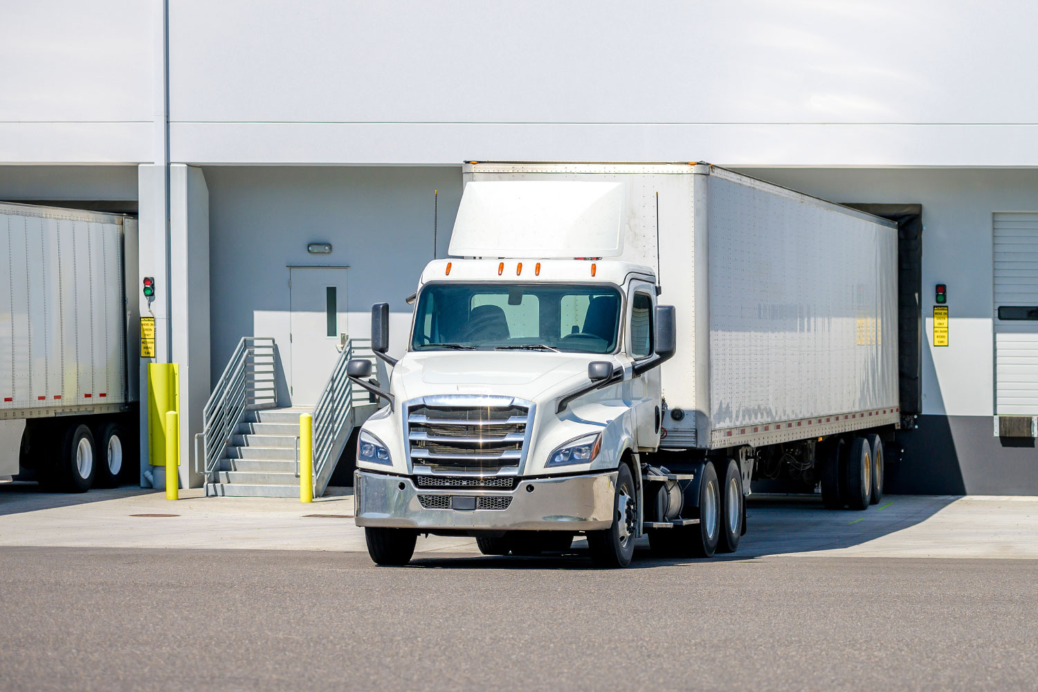 Rental-01 White tractor trailer sitting at a loading dock.