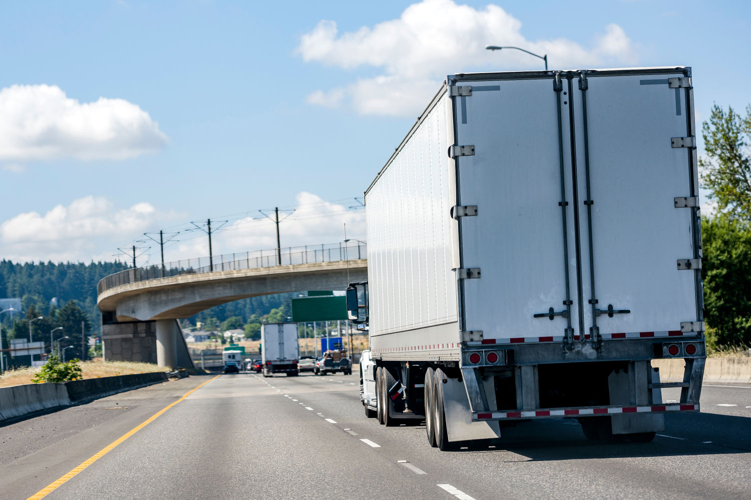 Rental-05 View from behind of a white box truck on highway.